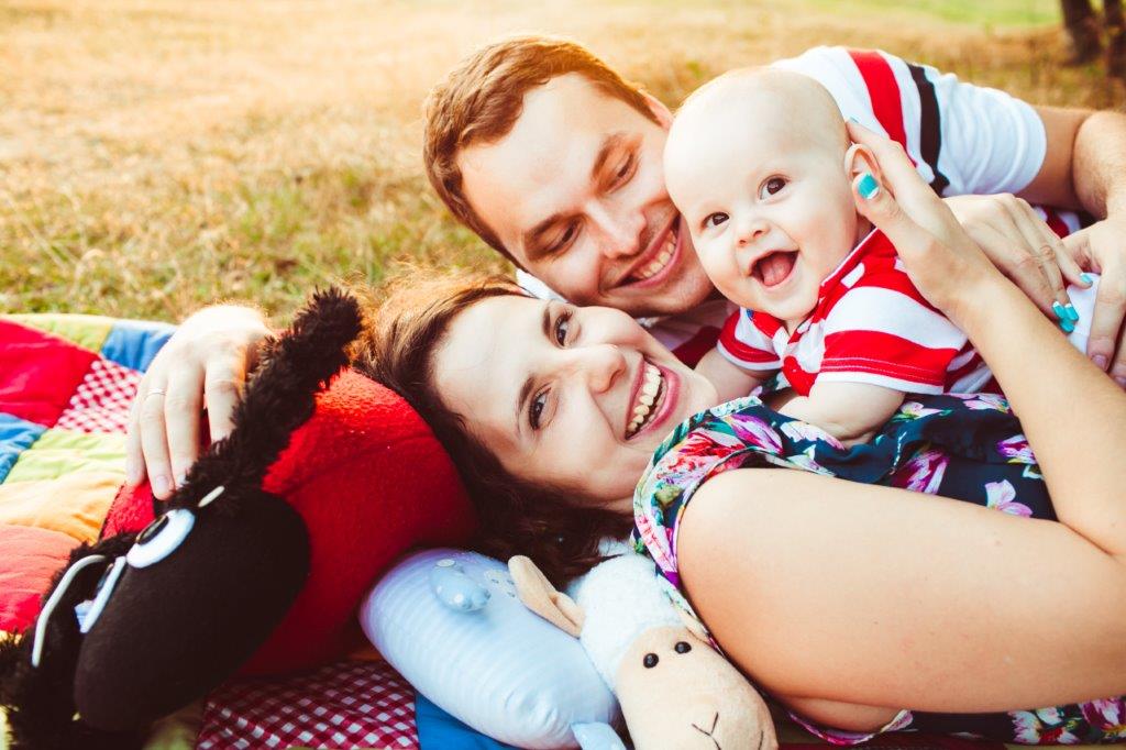A happy young couple with baby boy at park