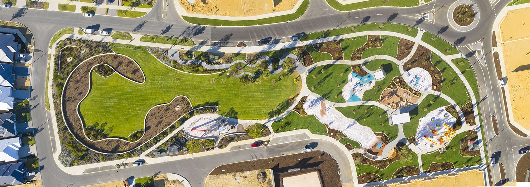 House and land packages are available in Move Homes near Brightwood Park. This is an aerial view of Brightwood Park, showing the bright green grass and fun equipment. There is so much running space.
