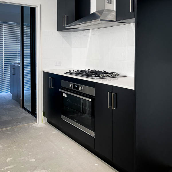A black kitchen with white tiles by Move Homes in Hilbert